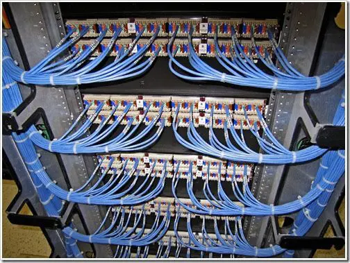 A bunch of blue wires hanging on the side of a rack.