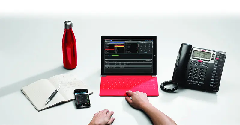 A person using a laptop on top of a desk.