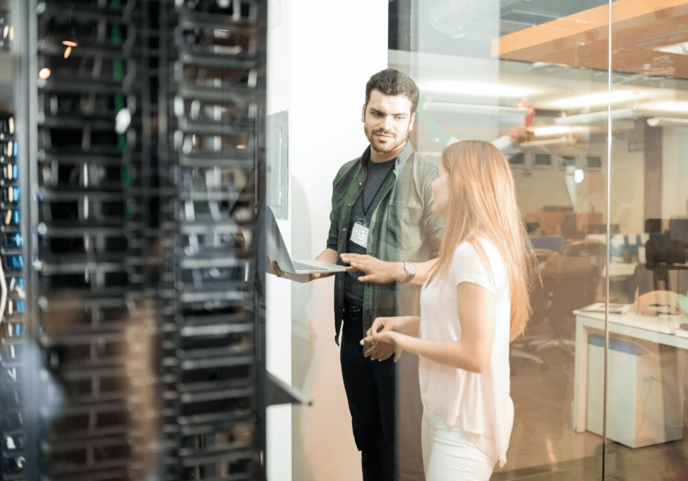 Two people discussing in a server room.