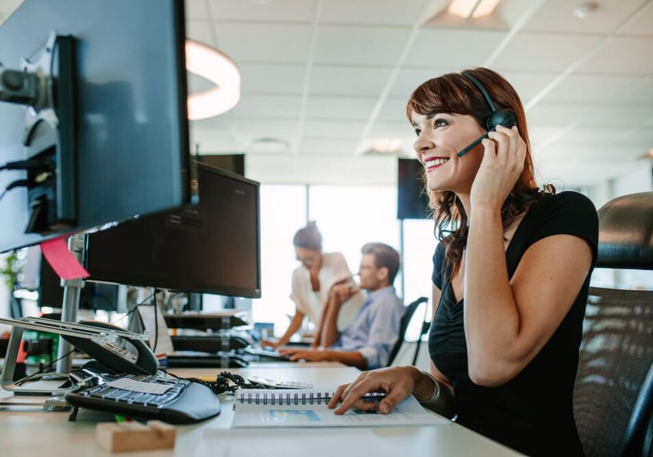 Corporate female employee using headset at desk with Virtual PBX solution.