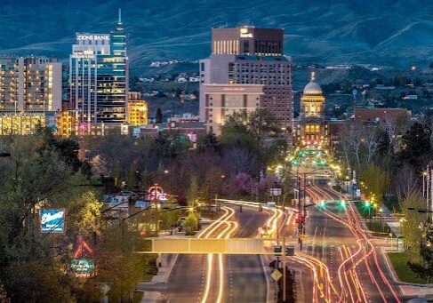 A city street with lights and buildings in the background.